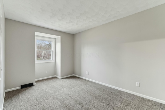 unfurnished room with a textured ceiling and carpet floors