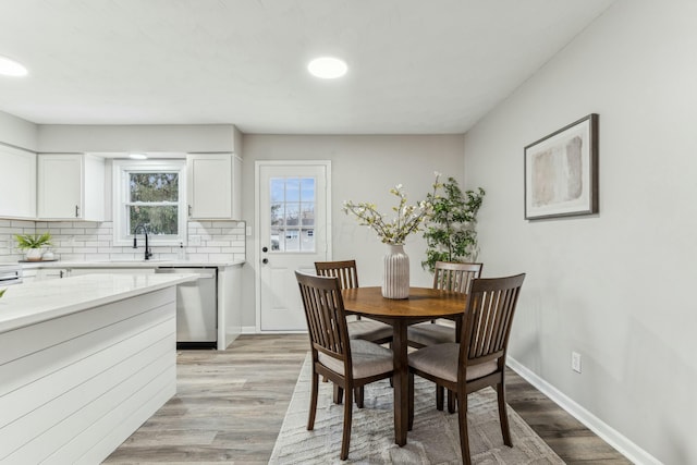 dining area featuring light wood-type flooring and sink