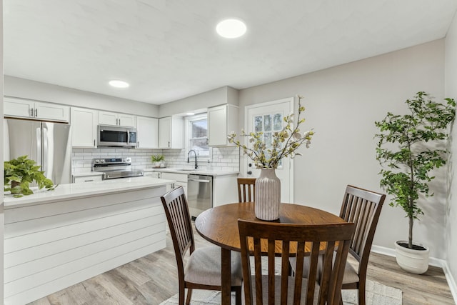 dining area with light wood-type flooring and sink