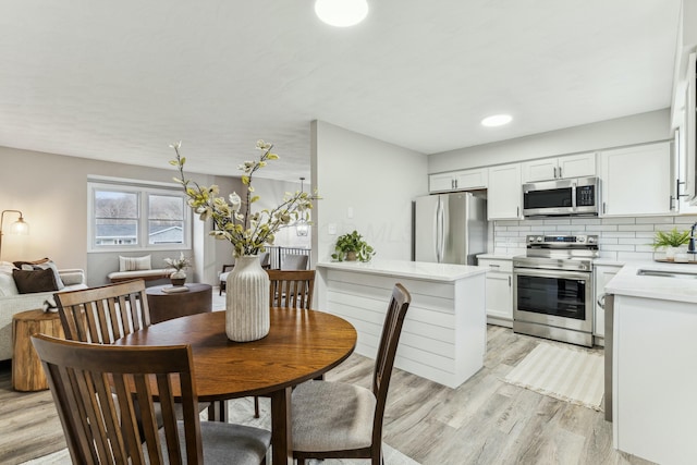 dining area with light wood-type flooring and sink