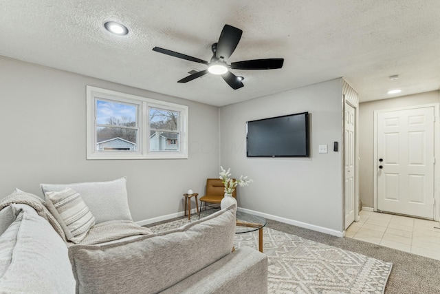 living room featuring a textured ceiling, ceiling fan, and light tile patterned flooring