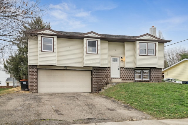 bi-level home with a garage and a front lawn