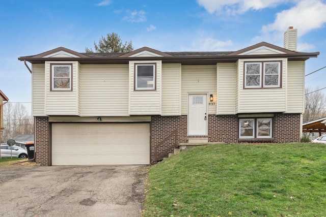 bi-level home with a garage and a front yard