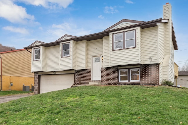 split foyer home with cooling unit, a garage, and a front lawn