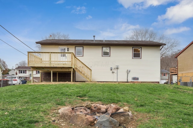 back of property with a deck and a lawn