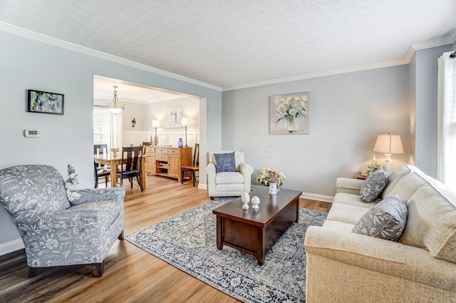 living room featuring a textured ceiling, hardwood / wood-style flooring, and ornamental molding