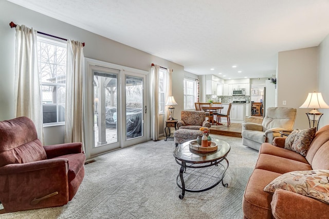 living room with a healthy amount of sunlight and light colored carpet