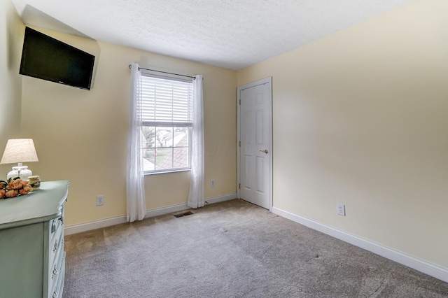 unfurnished bedroom with light carpet and a textured ceiling