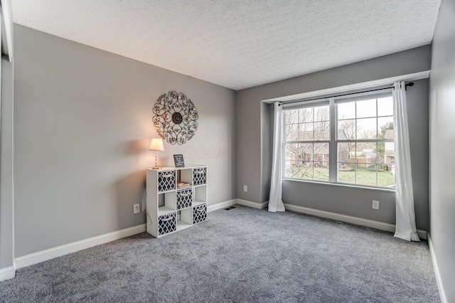 carpeted empty room with a textured ceiling