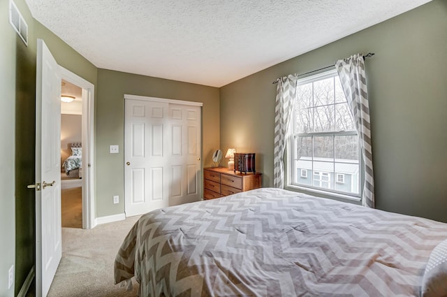 bedroom featuring light carpet, a textured ceiling, and a closet