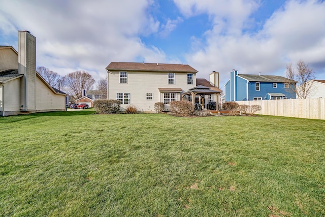 back of house with a gazebo and a yard