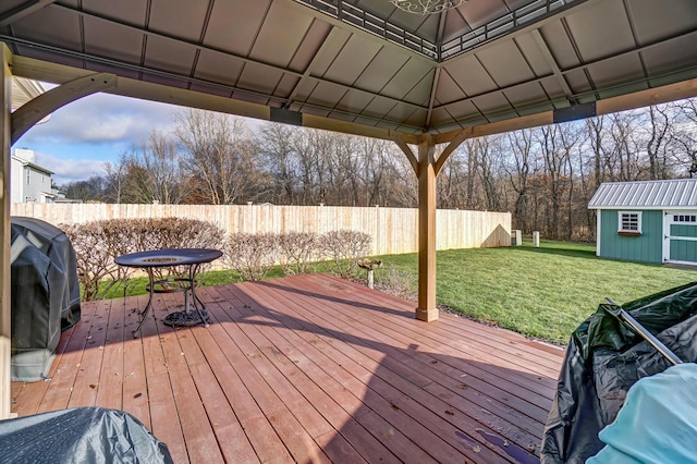 wooden deck with a gazebo, area for grilling, a storage shed, and a yard