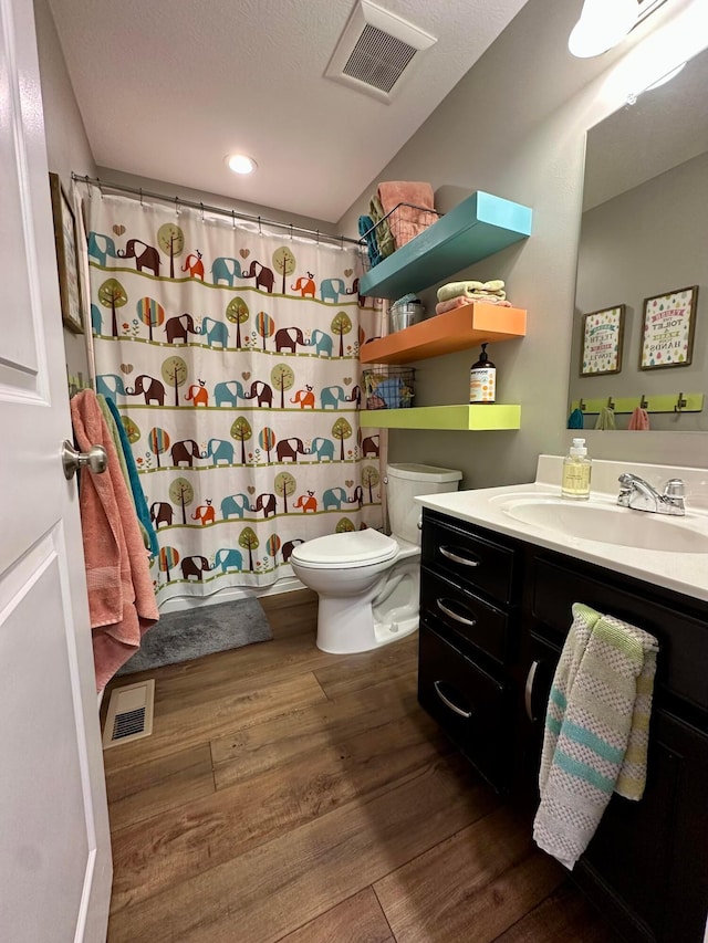 bathroom featuring a shower with curtain, vanity, hardwood / wood-style flooring, and toilet