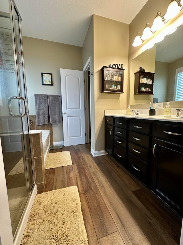 bathroom featuring hardwood / wood-style floors, vanity, and shower with separate bathtub