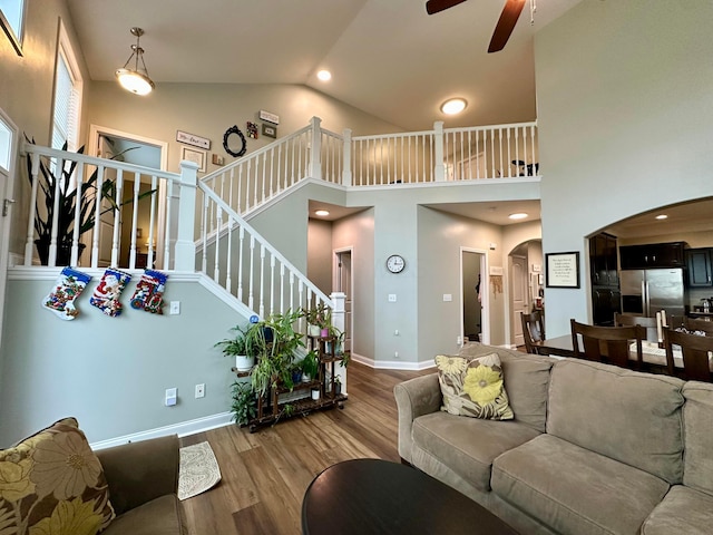 living room featuring ceiling fan, high vaulted ceiling, and light hardwood / wood-style floors