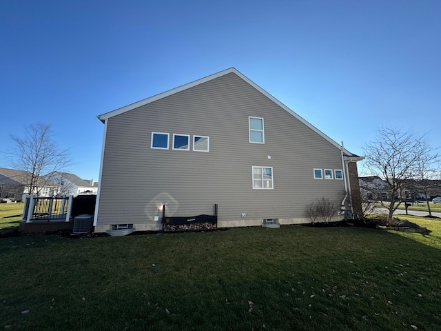 view of side of property with central AC and a lawn