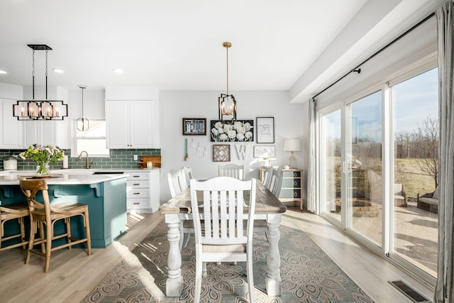 dining area featuring an inviting chandelier and light hardwood / wood-style flooring