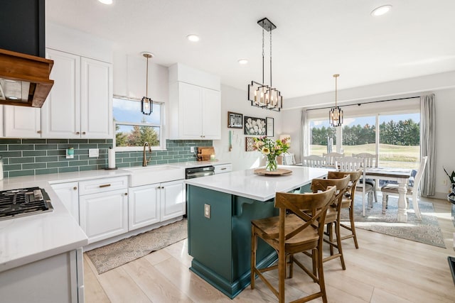 kitchen featuring white cabinetry, a center island, and light wood-type flooring