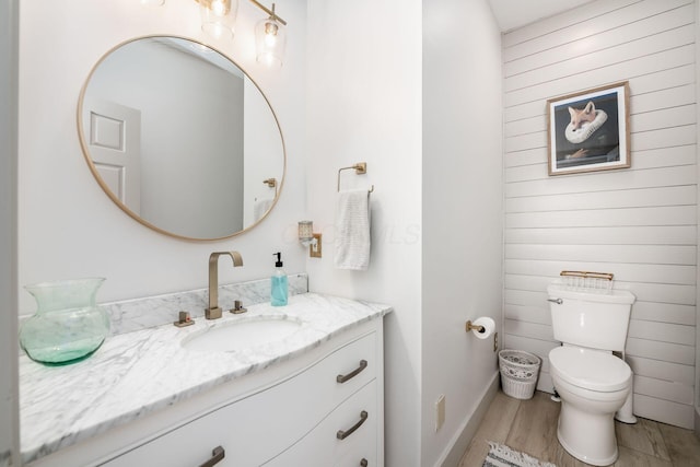 bathroom with vanity, toilet, and wood-type flooring