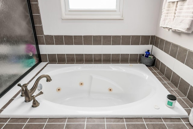 bathroom featuring a relaxing tiled tub