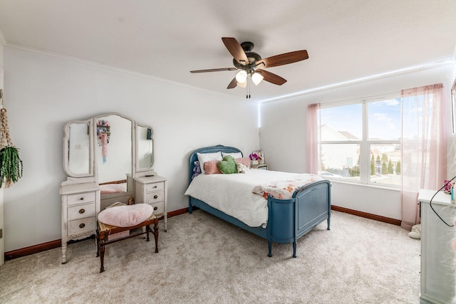 carpeted bedroom with ornamental molding and ceiling fan