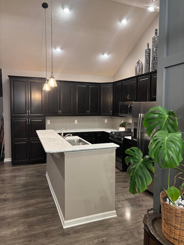 kitchen featuring lofted ceiling, sink, dark hardwood / wood-style floors, pendant lighting, and stainless steel appliances