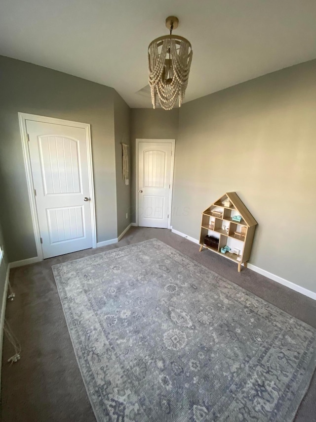 interior space with an inviting chandelier and dark carpet