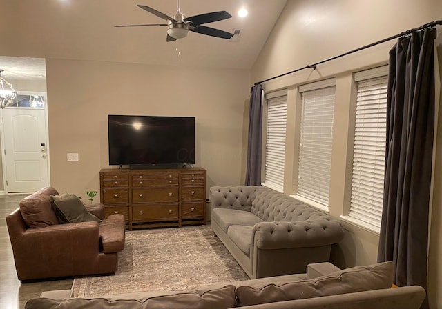 living room with lofted ceiling, light wood-type flooring, and ceiling fan