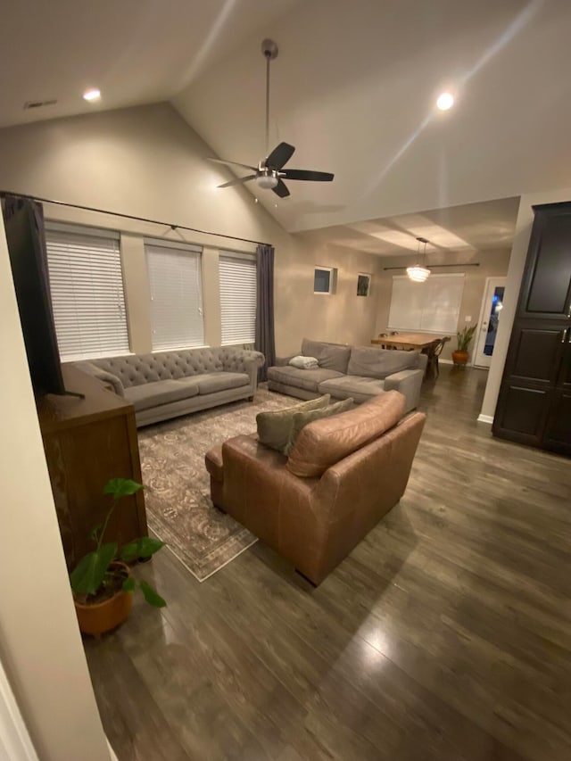 home theater with dark hardwood / wood-style flooring, high vaulted ceiling, and ceiling fan