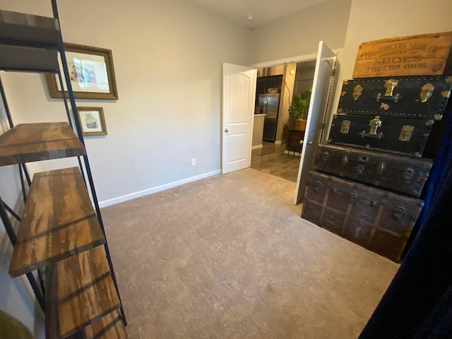 carpeted bedroom featuring black fridge