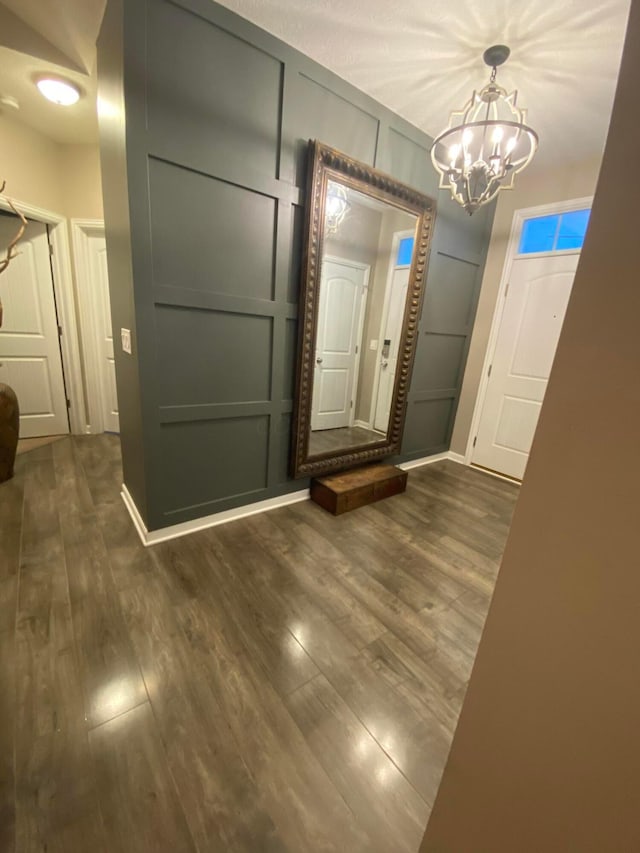 foyer entrance with dark hardwood / wood-style flooring and a notable chandelier