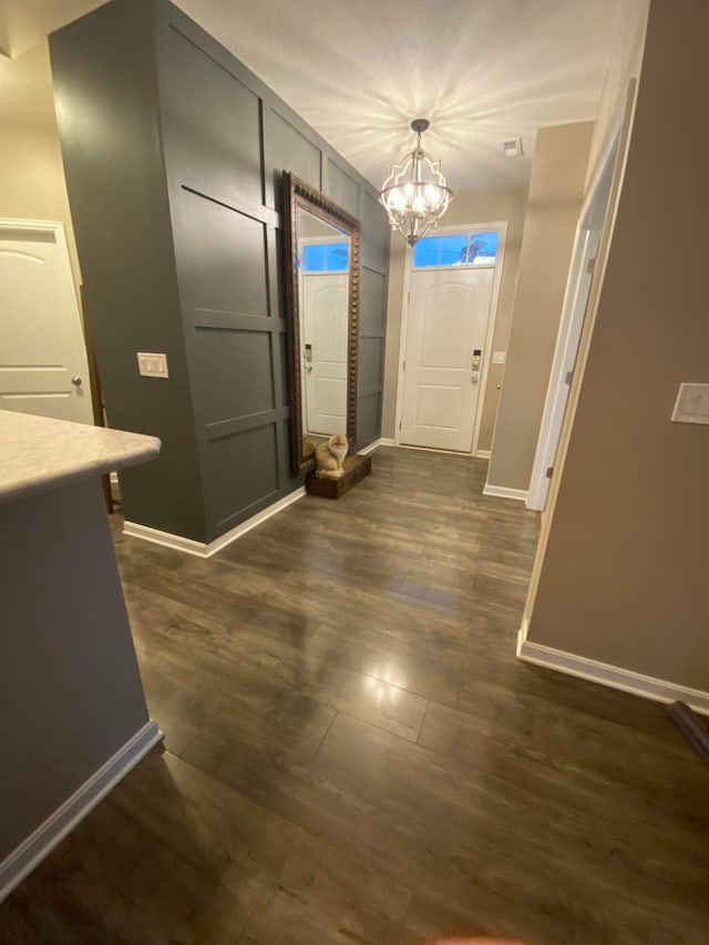 entrance foyer featuring dark hardwood / wood-style flooring and a notable chandelier