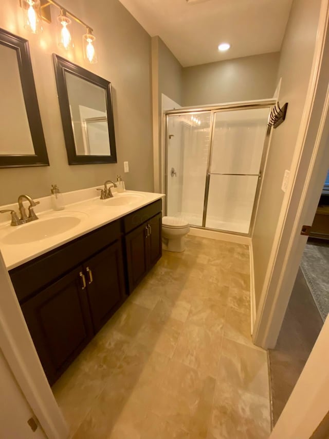 bathroom with an enclosed shower, vanity, and toilet