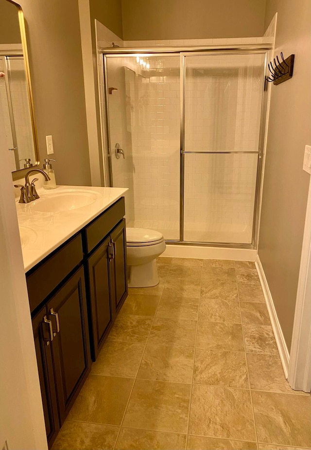 bathroom with a shower with door, vanity, and toilet