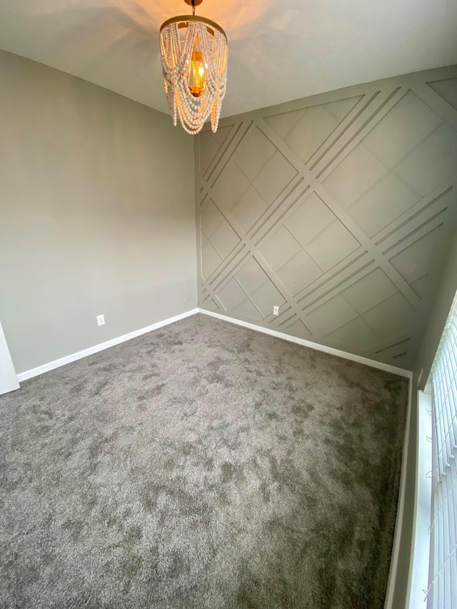 carpeted empty room with a notable chandelier