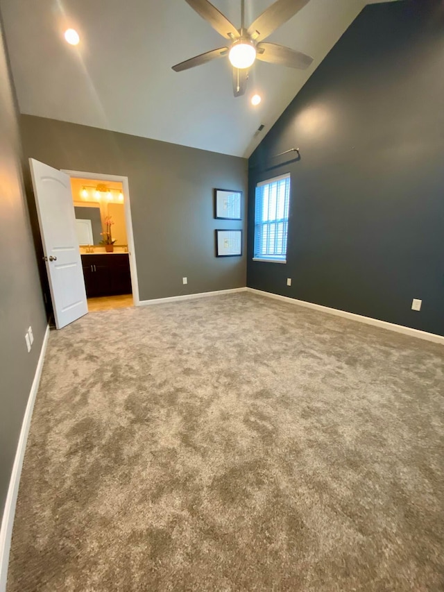 unfurnished bedroom with ceiling fan, carpet, high vaulted ceiling, and ensuite bath