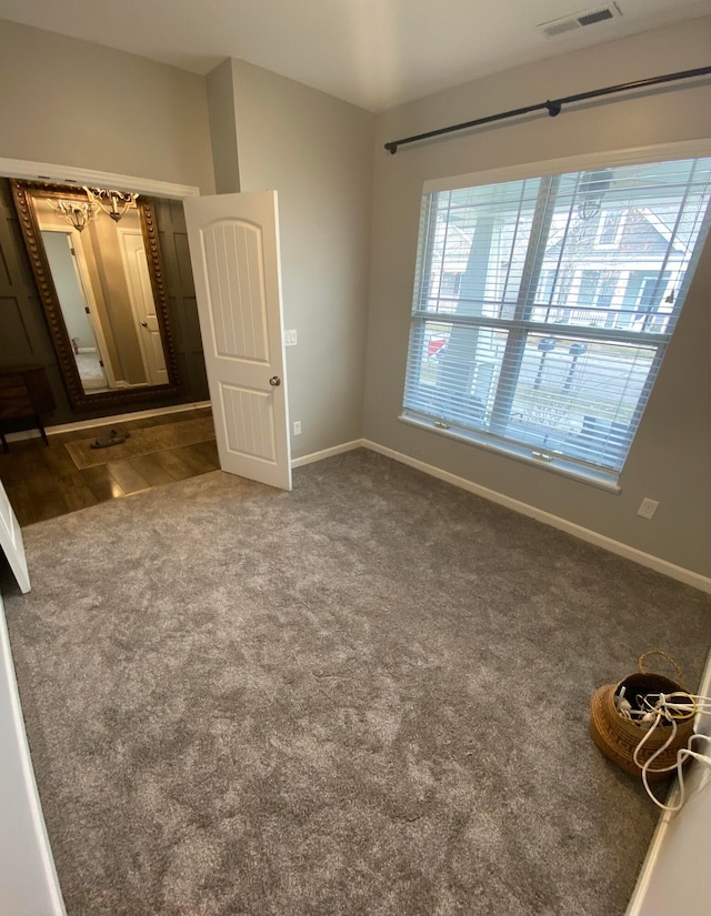 unfurnished bedroom with dark colored carpet