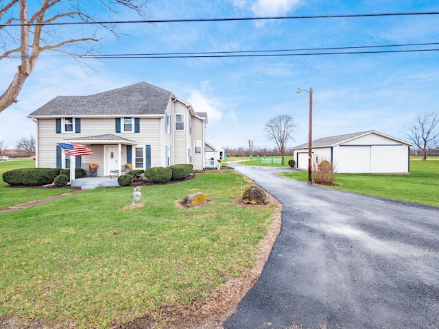 view of front of property with an outbuilding, a garage, and a front lawn