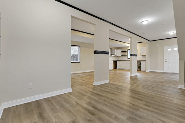 unfurnished living room with light wood-type flooring and crown molding