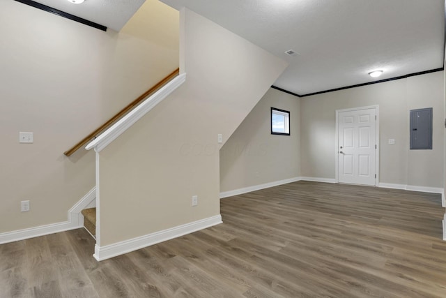 bonus room featuring a textured ceiling, electric panel, and light hardwood / wood-style flooring