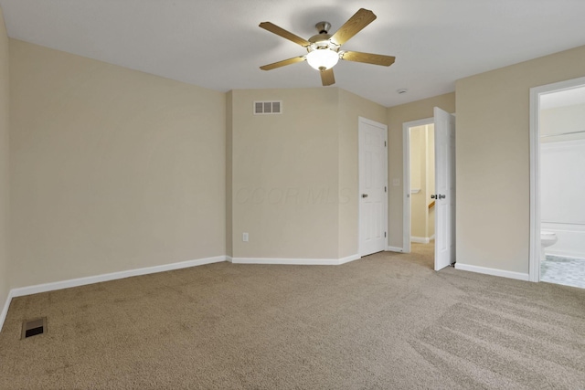 unfurnished bedroom with ceiling fan, light colored carpet, and ensuite bath