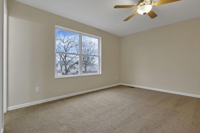 carpeted spare room featuring ceiling fan