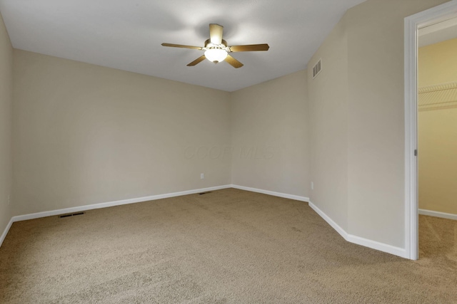 spare room featuring ceiling fan and carpet