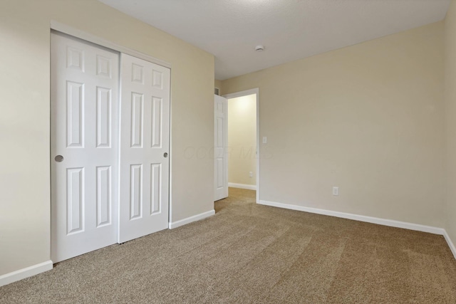 unfurnished bedroom featuring carpet and a closet