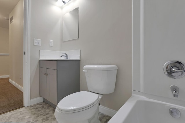 bathroom featuring vanity, a tub to relax in, and toilet