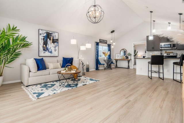 living room featuring a notable chandelier, light wood-type flooring, and vaulted ceiling