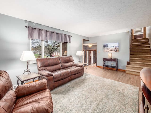 living room with a textured ceiling and light wood-type flooring