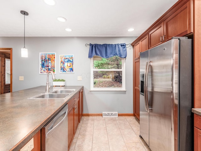 kitchen with pendant lighting, sink, light tile patterned floors, and stainless steel appliances