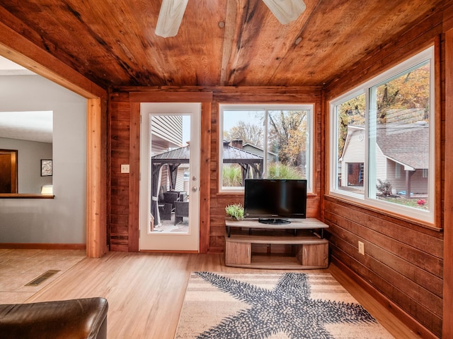 sunroom featuring ceiling fan, wood ceiling, and a wealth of natural light