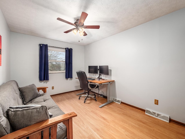 office area featuring ceiling fan, wood-type flooring, and a textured ceiling